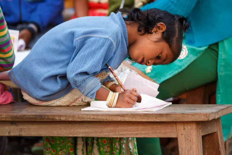 education indian girl child poor villager closeup writing paper pencil learning school to read write 50691441